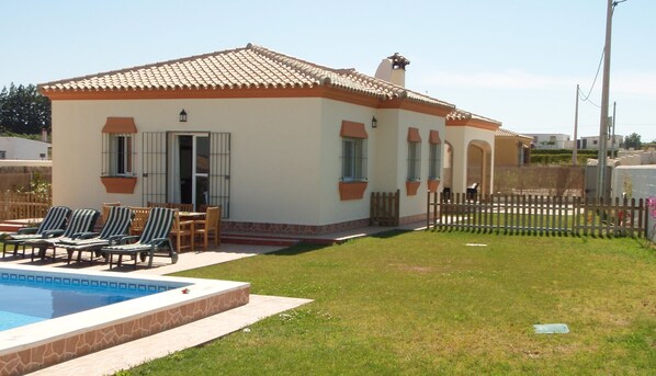 View of the villa, with a picket fence to separate the pool area.