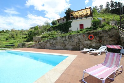 Old stone house with swimming pool and river.