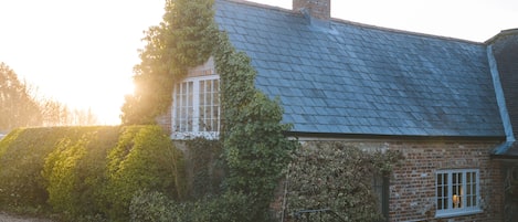 The Brew House forms the east wing of the Grade II listed Knighton Farmhouse