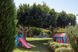 Playground area for children and a hammock, next to the swimming pool