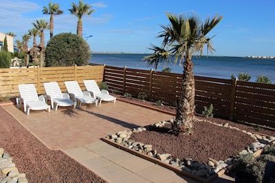 Apartamento confort directamente en la playa con un jardín mediterráneo y una vista soñada del agua