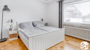 Im Schlafzimmer sind ein Doppelbett, ein Tisch, Stühle und ein Schrank.