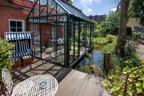 Blick aus der Küche zum Wintergarten mit Teich und Terrasse (Haupthuus)