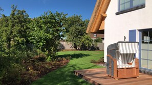 Die West-Terrasse mit Strandkorb und Blick in den Garten