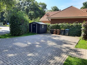 Fahrrad- und Gerätehaus neben dem Parkplatz