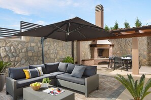 Comfortable lounge terrace, a large dining table and a charcoal grill