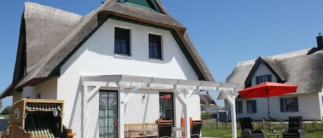 Südterrasse mit breitem Strandkorb.