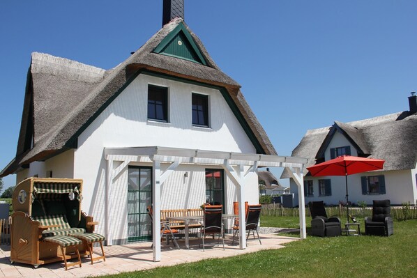 Südterrasse mit breitem Strandkorb.