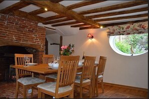 Dining room with seating for 6 and inglenook brick fireplace.