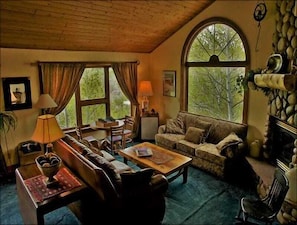 The First of 3 Living Rooms features Vaulted Ceilings, River Rock Fireplace & Game Table