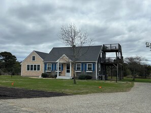 Front of house showing pea stone gravel driveway entrance. Newly planted grass.