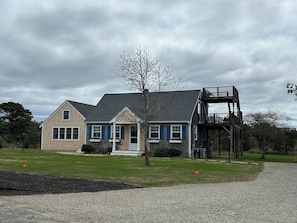 Front of house showing pea stone gravel driveway entrance. Newly planted grass.