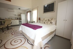 Downstairs features a queen bed with luxury covers and tons of pillows.