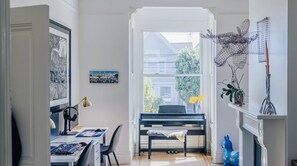 Kids play room/dual office with electric piano, lots of light and art.