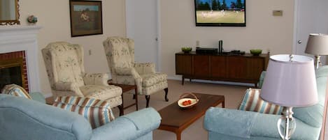 Living Room view with entrance to Kitchen and Dining Room. Large screen HDTV