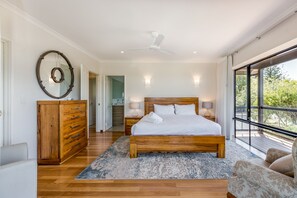 The primary bedroom on the top floor is a dreamy retreat with a king bed, private veranda access, and ocean views.