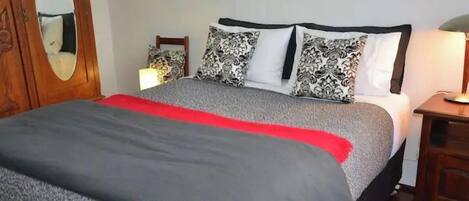 Red room bedroom with queen bed, bedside lights, wardrobe and dressing table