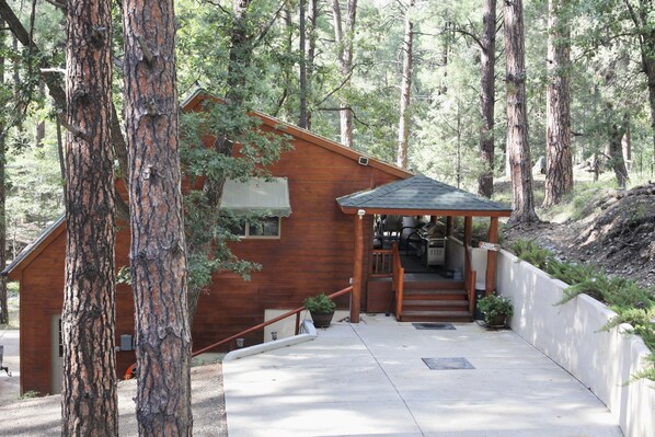 Surrounded by mature trees, the cottage has a designated parking spot.