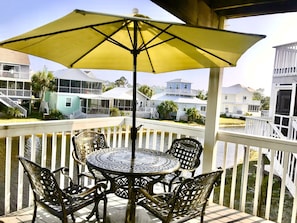 Sunny deck with table, chairs, & umbrella; overlooking fish & turtle pond.