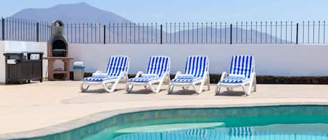 Outside sun lounger and barbecue area with Femes mountains backdrop 