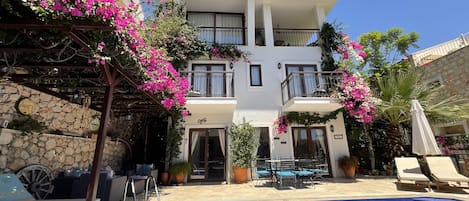 Villa Elsa’s beautiful pool terrace with shady pergola area & colourful gardens