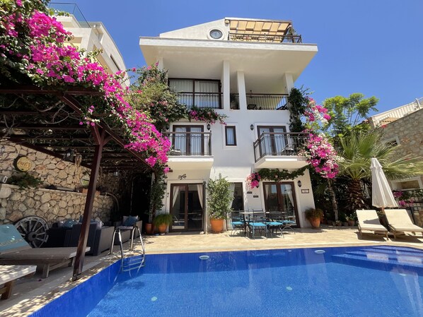 Villa Elsa’s beautiful pool terrace with shady pergola area & colourful gardens