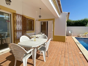 The attractive, sunny, south facing terrace with 2 large tables & chairs, overlooking  long 10 m x 2.10 meters, with depths from 1.0 to 1.8 metres, the garden lawn.