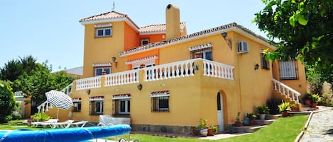 Front of the villa showing part of garden and pool - has cover and safety fence