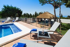 pool area with thatched gazebo all with sea views.