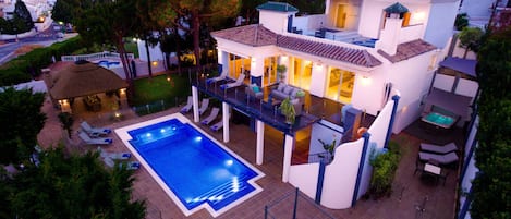 aerial night shot of pool and villa with la cala de Mijas  in the back ground.