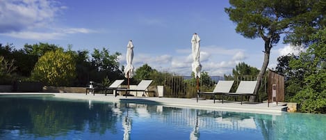 Piscine a debordement chauffee et securisee par un rideau electrique