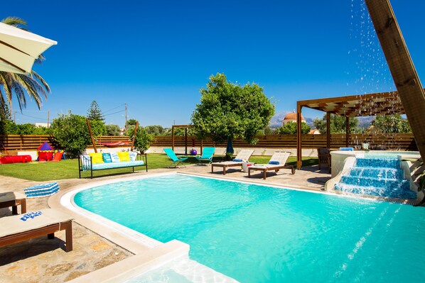 The outdoor area is equipped with sun beds and umbrellas.