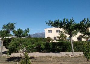 Casa Pau from outside the garden with mountains behind