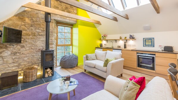 Lounge and kitchen area, light streaming in from roof lights and new windows