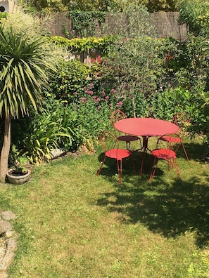 Coin repas dans le jardin devant la facade de la maison