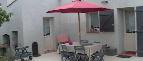 Terrasse avec une cour fermée et un  barbecu