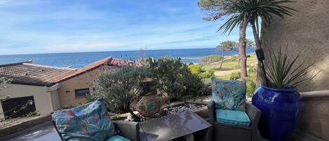 terrasse vue mer avec table et chaises et salon de jardin