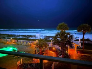 Sterling Sands night view of the pool/hot tub and beach.