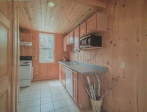 Kitchen is "L" shaped. Refrigerator and dining table are around corner.