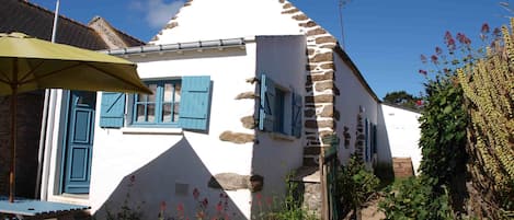 L'extérieur de la maison et son petit jardin clos