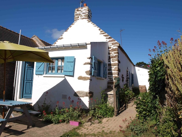 L'extérieur de la maison et son petit jardin clos