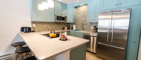 Newly remodeled kitchen with stainless steel appliances and quartz countertops.
