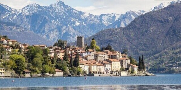 The Rezzonico Village and its Castle seen from Como Lake; behind the mountains.