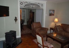 Another view showing wall mounted TV and gas fired woodstove