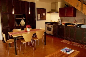 Dining table for 6 people. Sub-Zero refrigerator- freezers right of yellow vase.