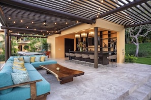 An outdoor living room and bar, great for watching games or movies.