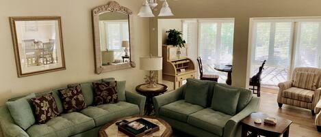 Living room with spacious sun room in the background with great natural light