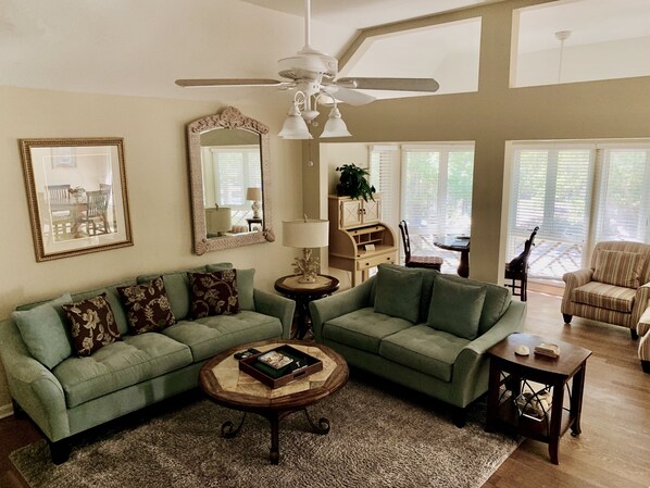 Living room with spacious sun room in the background with great natural light
