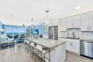 Spacious kitchen and open concept living area with views of the beach and Gulf.