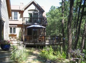 back of the house with deck and upstairs balcony